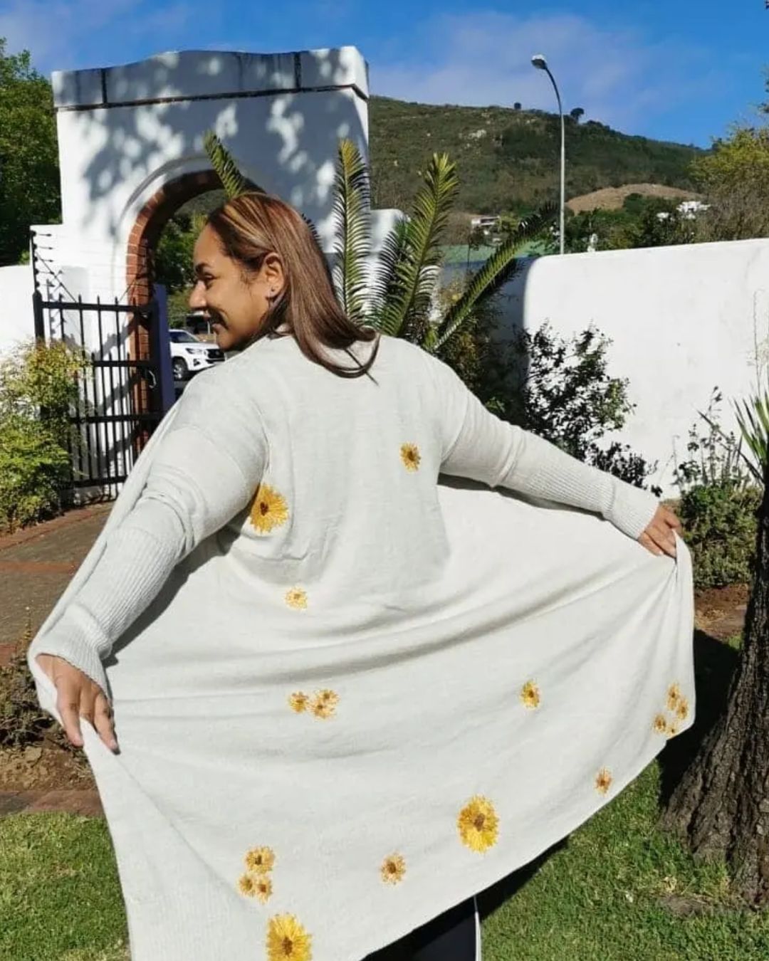 Cardigan with sunflowers embroidered over the holes